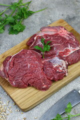 Daging sapi mentah or raw beef on preparation for cooking with some spice. Beef on Eco friendly package and chopping board with wooden rustic background.