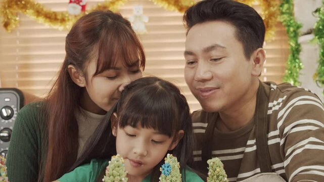 Happy Asian family spending times to prepare Chritsmas and Happy news year Celebrete. kids parent and grandparent doing ginger breads and bakery enjoy and dancing in kichen at home