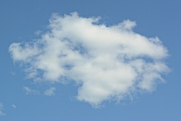 Fototapeta premium white cloud against a blue sky, illuminated by the sun from one side