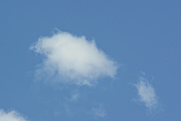 white cloud against a blue sky, illuminated by the sun from one side