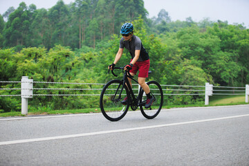 Fototapeta premium Asian woman cycling on summer trail