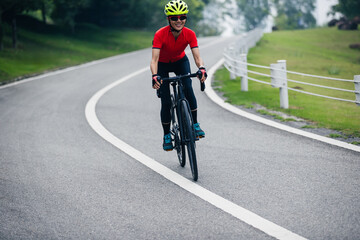 Asian woman cycling on summer trail
