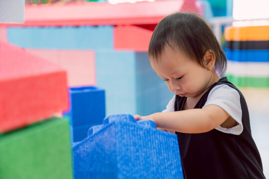 Portrait of Asian little boy playing with colorful blocks at home or nursery. Toys for kids. Playtime For baby. Son age one year six month.