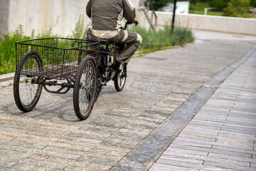Obraz premium worker pedals a tricycle with a large rear cargo basket, a blend of utility and sustainable transport