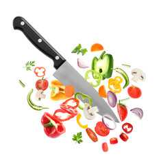 Knife cutting different vegetables in air on white background