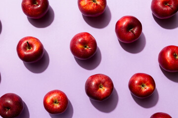 Many red apples on colored background, top view. Autumn pattern with fresh apple above view