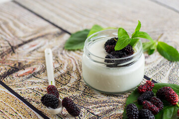 homemade sweet yogurt in a jar with black mulberries
