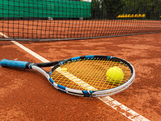 Tennis racquet and tennis ball on clay court