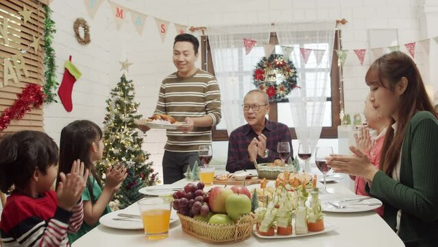 Happy Asian family spending times to prepare Chritsmas and Happy news year Celebrete. kids parent and grandparent doing ginger breads and bakery enjoy and dancing in kichen at home