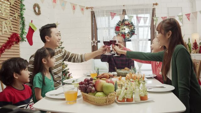 Happy Asian family spending times to prepare Chritsmas and Happy news year Celebrete. kids parent and grandparent doing ginger breads and bakery enjoy and dancing in kichen at home