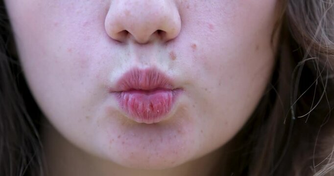 Close-up of woman's lips kissing, mole above lip
