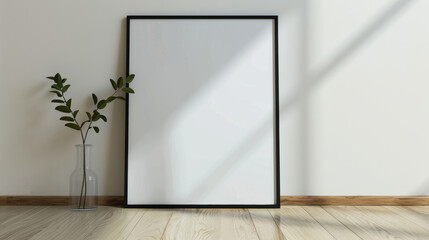 Fototapeta premium Against a soft white background, a minimalist black wooden frame poster mockup stands upright on a clean floor.