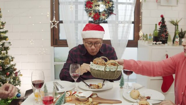 Happy Asian family spending times to prepare Chritsmas and Happy news year Celebrete. kids parent and grandparent doing ginger breads and bakery enjoy and dancing in kichen at home