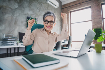 Photo of lucky good mood age lady agent dressed formal shirt winning game modern gadget indoors...