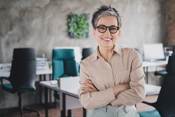 Photo of happy charming senior lady assistant wear formal shirt arms crossed smiling indoors...