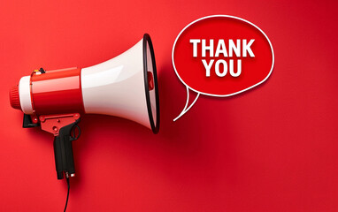 White loudspeaker or megaphone on red background. Next to it is the inscription "Thank You", symbolizing gratitude.