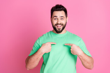 Photo of impressed good mood nice guy with stylish beard dressed green t-shirt indicating at himself isolated on pink color background