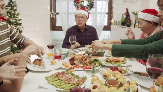 Happy Asian family spending times to prepare Chritsmas and Happy news year Celebrete. kids parent and grandparent doing ginger breads and bakery enjoy and dancing in kichen at home