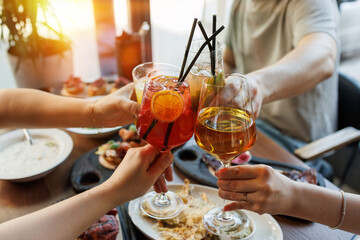festive toast closeup showing hands holding various drinks cocktails and wine