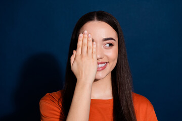 Photo of lovely adorable woman wear orange clothes arm face look empty space isolated on dark blue color background