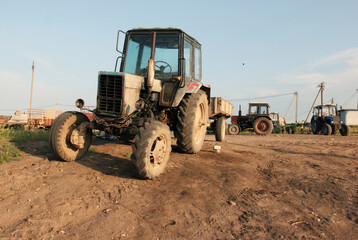 Fototapeta premium A Rusty Tractor Stands Tall in a Rural Field on a Sunny Day