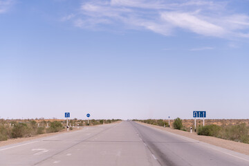 A road with a blue sign that says 1. The road is empty and there are no cars on it