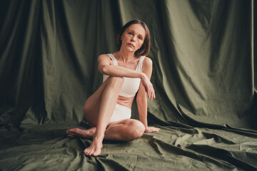 Obraz premium Unretouched photo of old lady feel gorgeous sit wear white lingerie isolated green color background