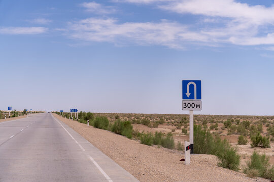 A road with a sign that says 300 meters ahead. The road is empty and the sky is blue