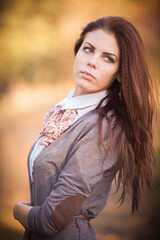 Fototapeta premium Autumnal Beauty: Brunette Girl in the Enchanting Forest
