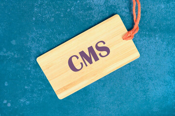 Business concept. CMS - short for Content Management System on a card with a string