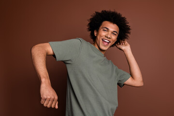 Photo portrait of attractive young man dancing enjoy discotheque dressed stylish khaki clothes isolated on brown color background