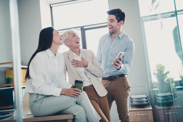 Photo of business people relax laughing jokes from social network gadget in workstation workplace