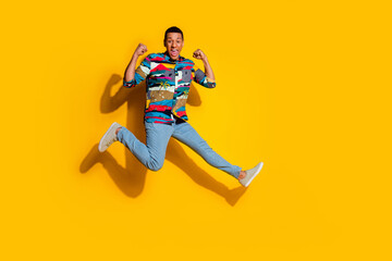 Full length photo of nice young male running winning dressed stylish colorful garment isolated on yellow color background