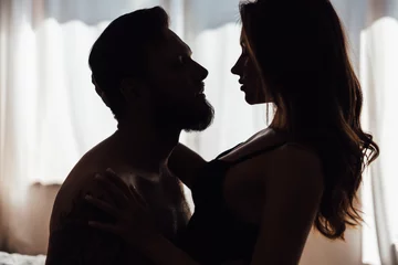 Couple kissing in darkness. Young woman and man embracing in bedroom. Dating concept © Maria Vitkovska