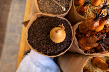 A bunch of spices are displayed in a variety of bags. The spices include cinnamon, nutmeg, and cloves