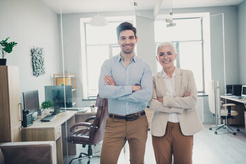 Photo of confident positive business people man woman cross hands standing in modern office
