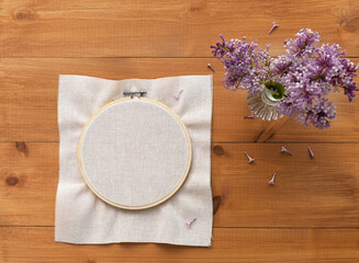 Needlework and craft concept. Light canvas is stretched into hoop for hand embroidery with cross...