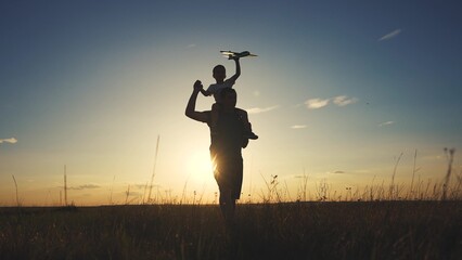 Silhouette of father and son bending his neck. Daughter parent beach concept. A father walks his child around his neck. Silhouette of a father and lifestyle son walking around the neck of a child.