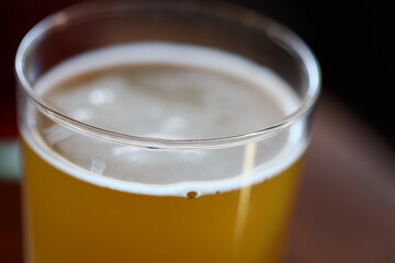 A close-up view of a glass of beer sitting on a table