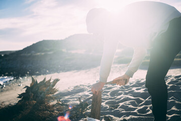 Person chops firewood at sunset on the beach in Baja, Mexico