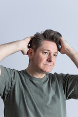 Portrait of a smiling mature man with gray hair and toupee touching his hair with both hands. Copy Space. Concept of stylish, masculine, stylish hairstyle and hair care