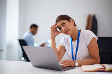 Pensive businesswoman working on laptop in  office.