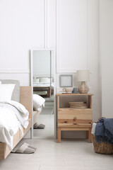 Stylish living room interior with bed, bedside table and lamp