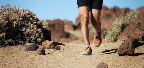 Trail running man on mountain path exercising