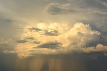 a stormy cloud in the sky with rainbow and rain 