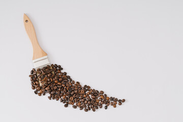 Creative layout made with paintbrush and roasted coffee beans on white background. Minimal coffee concept. Coffee art aesthetic idea. Flat lay composition. Top of view.