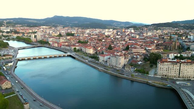 Panoramic aerial view of Pontevedra city at sunset. Drone descending close to River Lerez promenade. Famous travel destination in Galicia, Spain. View of old town center. 