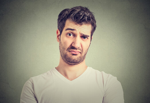 Closeup portrait of skeptical man looking suspicious, some disgust on his face mixed with disapproval isolated on gray background.