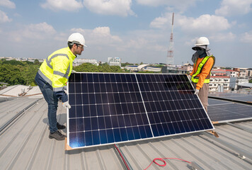 Men technicians carrying photovoltaic solar moduls on roof of factory on the morning. Installing a Solar Cell on a Roof. Solar panels on roof. Workers installing solar cell power plant eco technology.