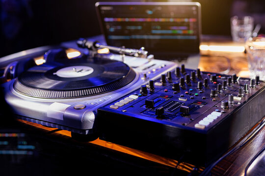 A close-up view of a professional DJ mixing console with various knobs and sliders.